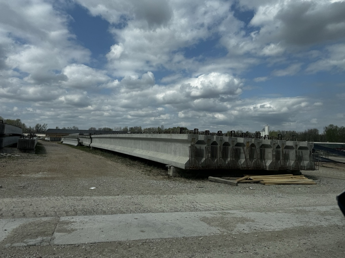 Row of prestressed concrete bridge girders at a Con-Fab precast manufacturing yard