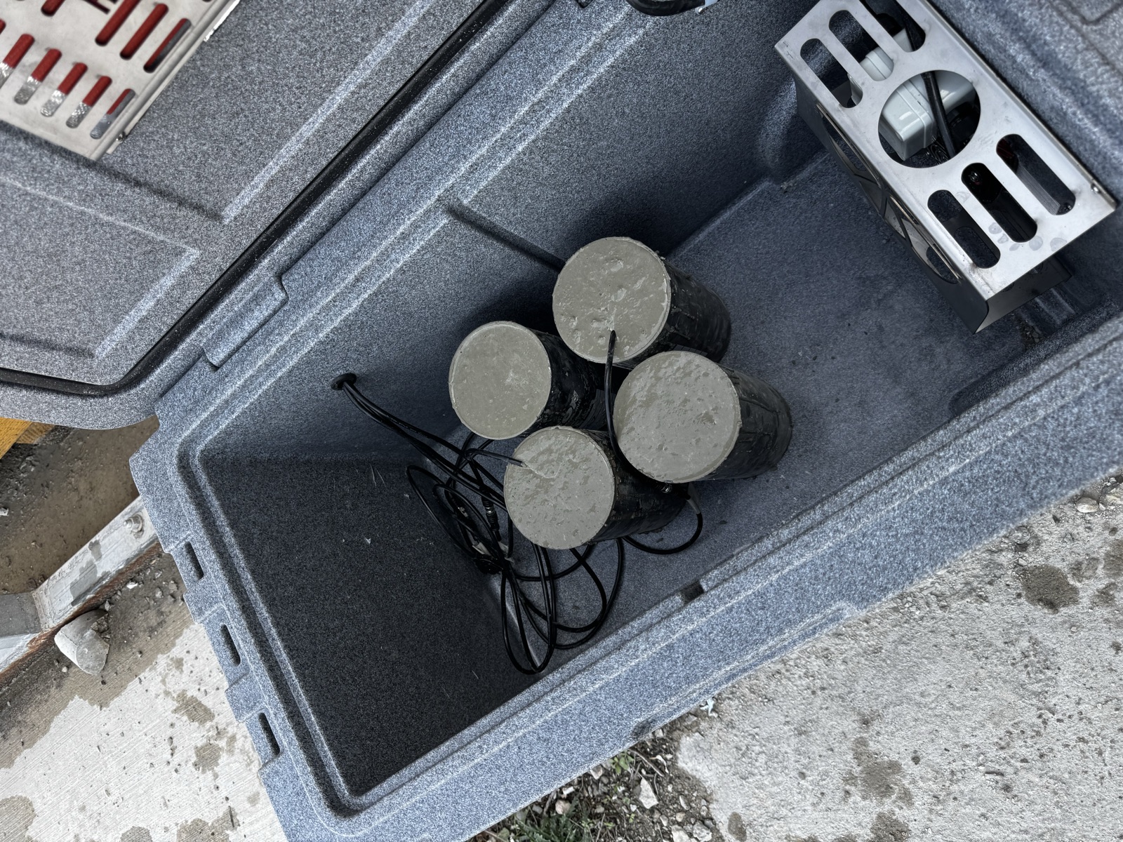 Concrete test cylinders inside SensyCure Match-Cure curing box with temperature-controlled environment